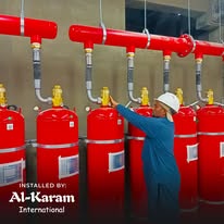 Technician beside a bank of fire suppression cylinders